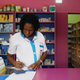 A vendor writes as she stands in a legal pharmacy in Abidjan, Ivory Coast